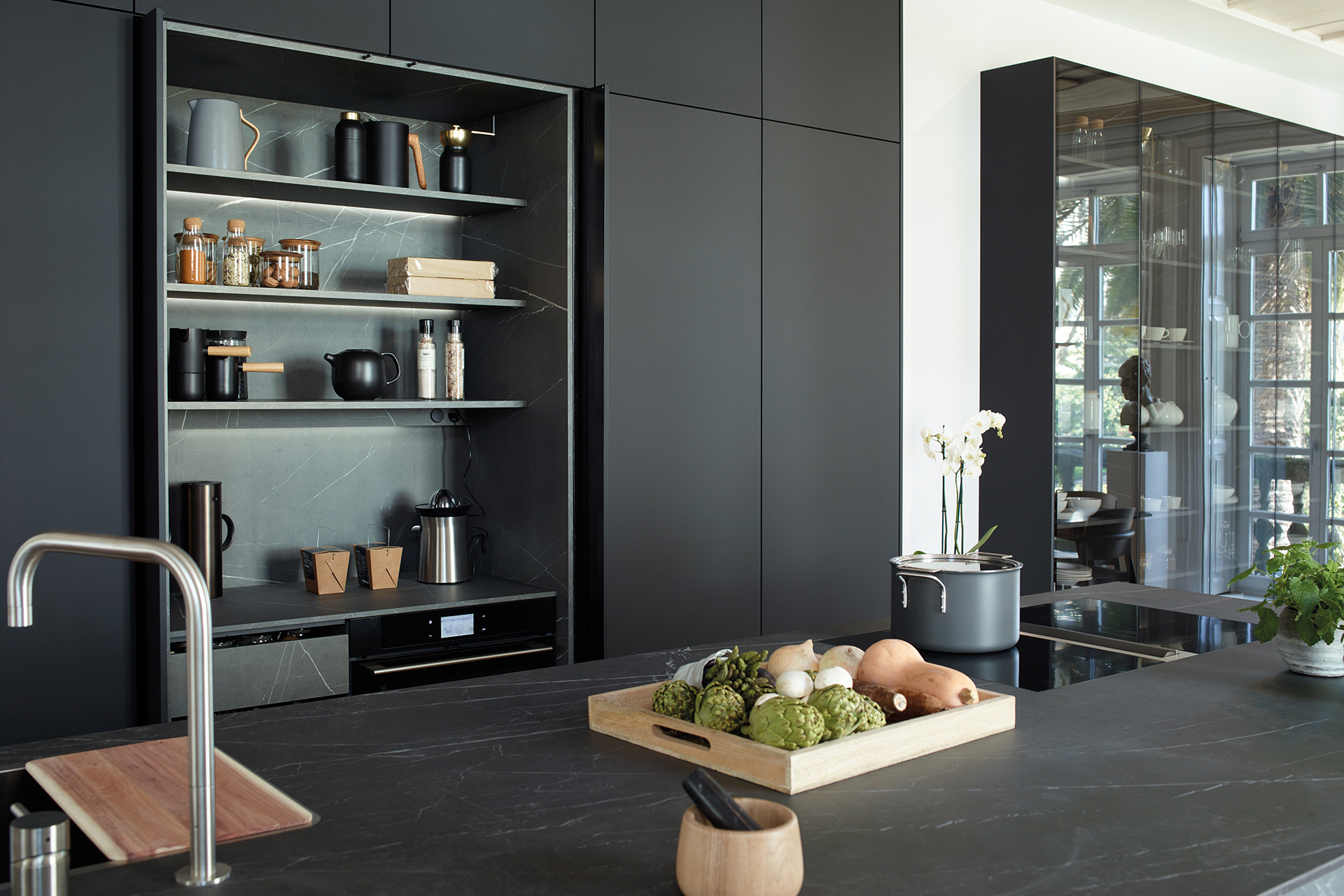 Cozinha preta com ilha aberta para a sala de estar e a sala de jantar, equipada com novos móveis concebidos pela Santos