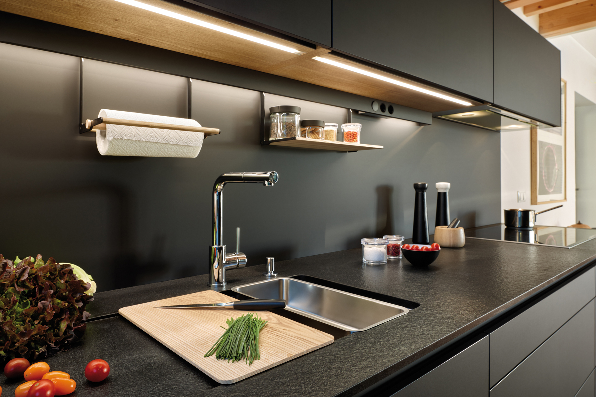 Black parallel kitchen that opens into the dining room, fitted with cabinets designed by Santos
