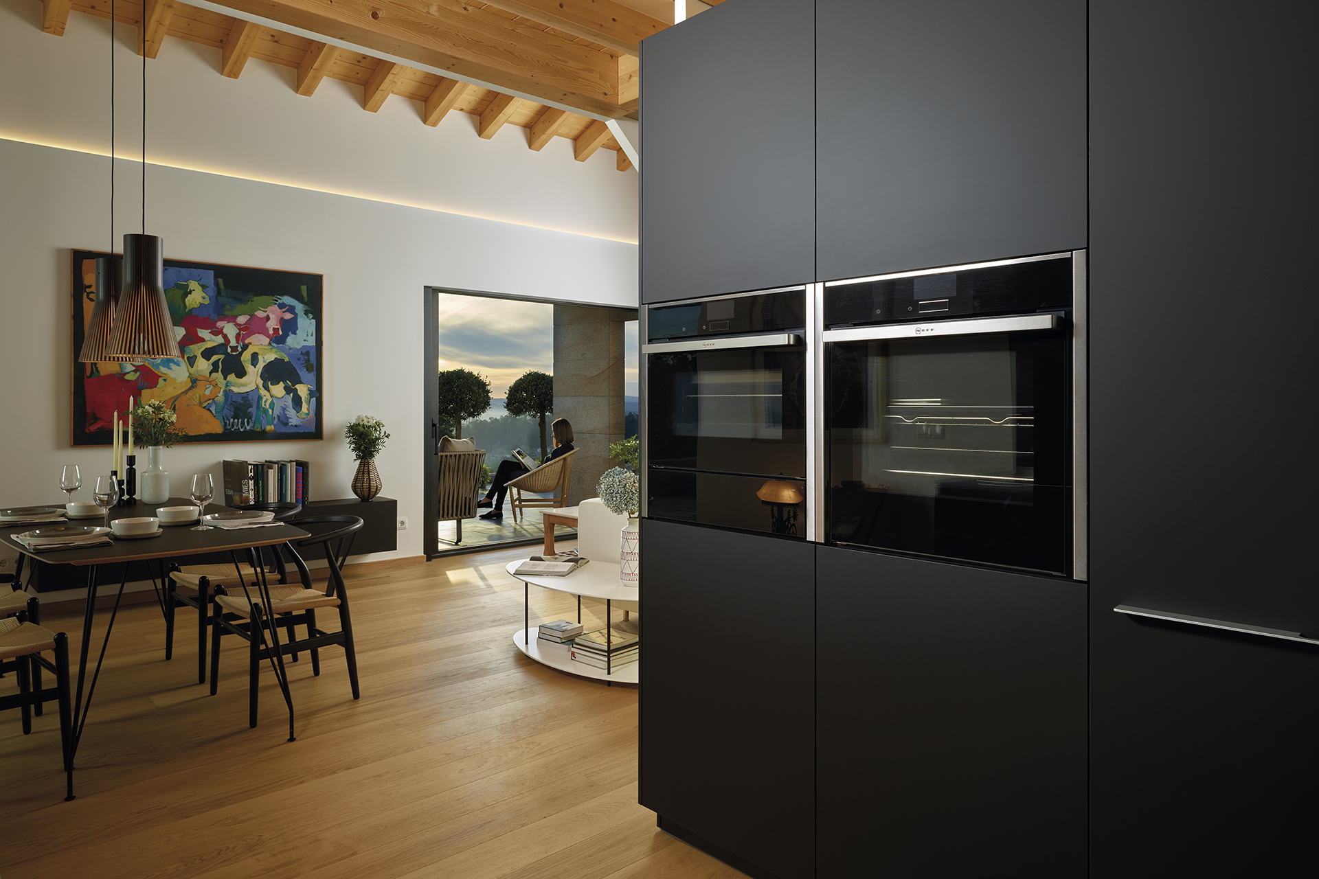 Zwarte parallelle open keuken naar de woonkamer, ingericht met door Santos ontworpen meubels
