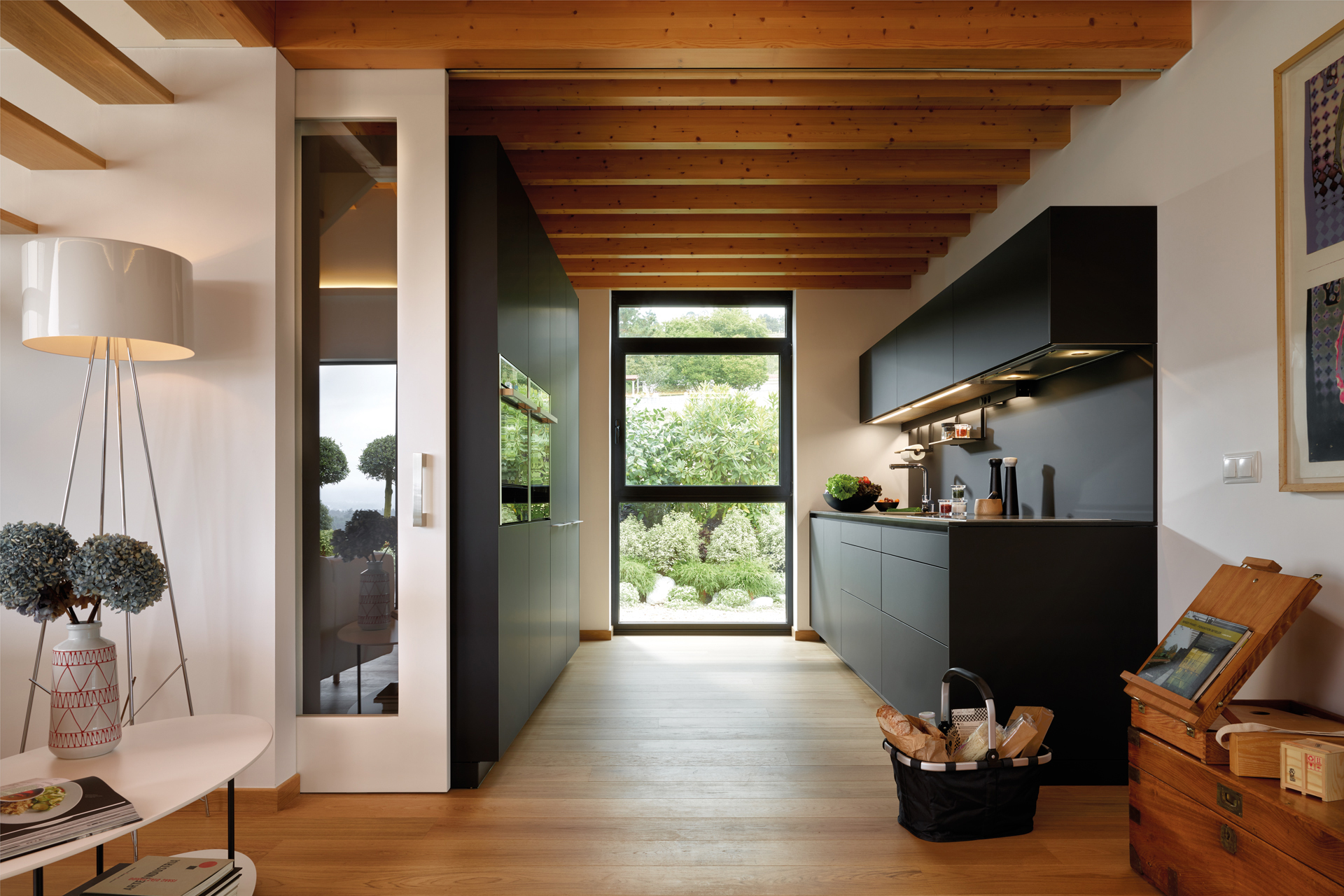 Cocina negra en paralelo abierta al comedor, equipada con muebles diseñados por Santos