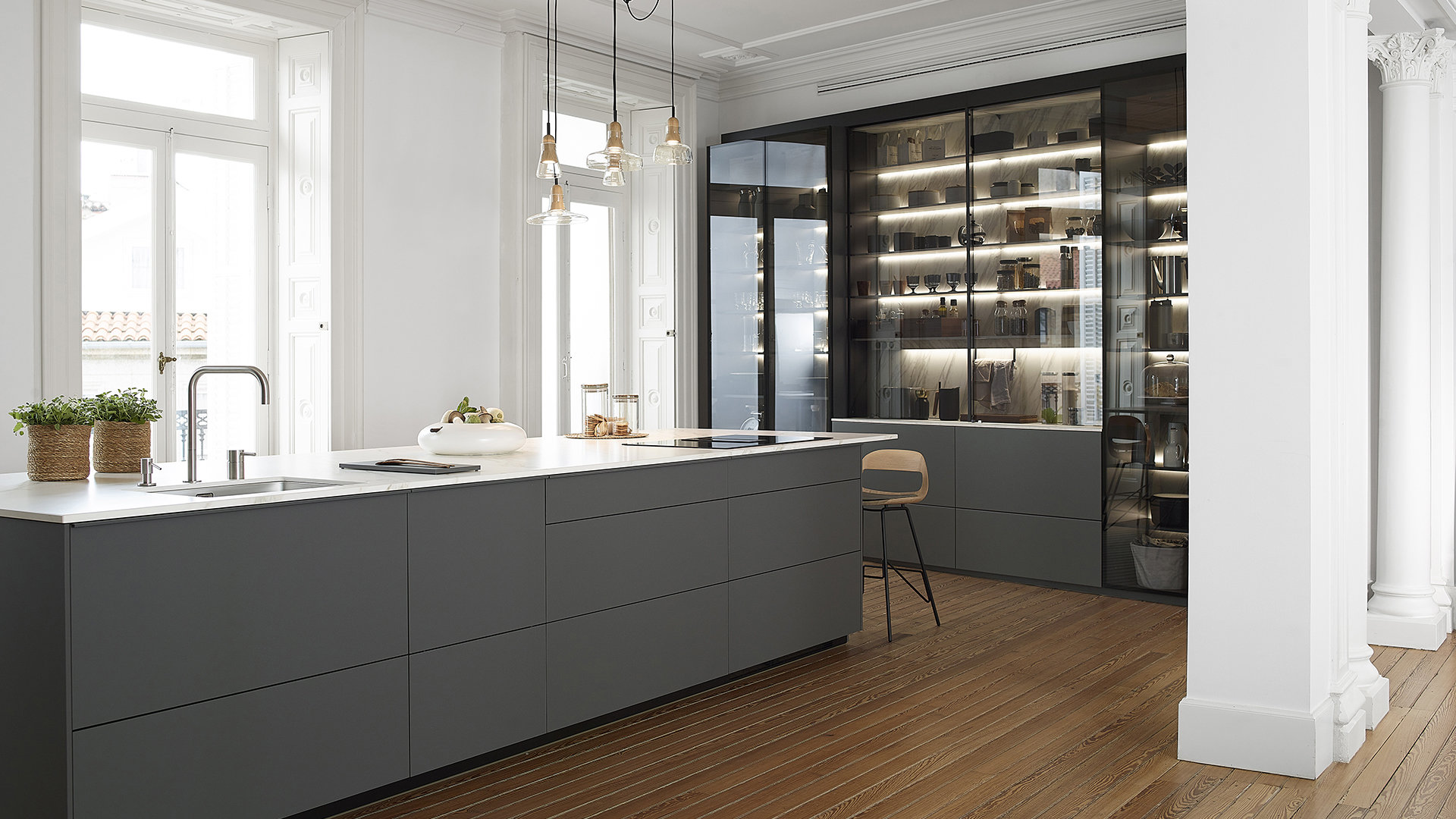Open-plan grey Santos kitchen with island and glass door unit