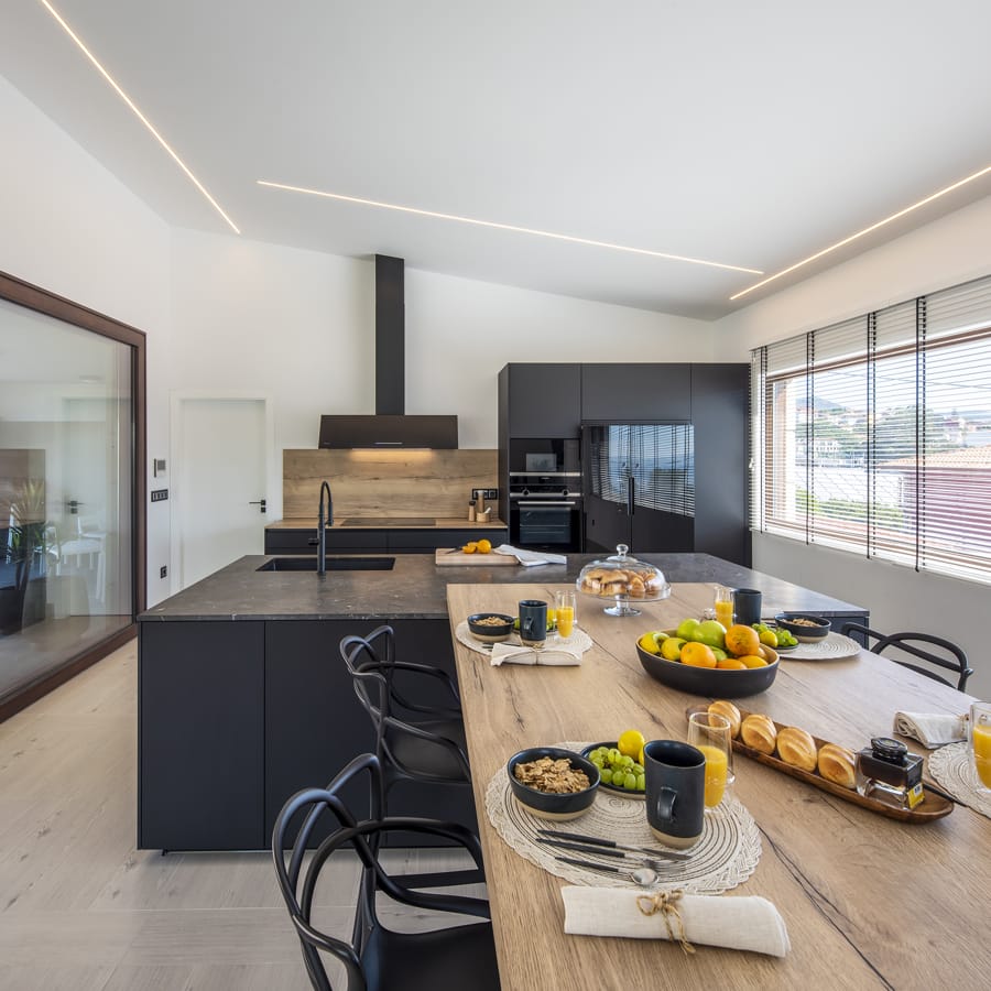 Black and wood kitchen with island, table and large windows