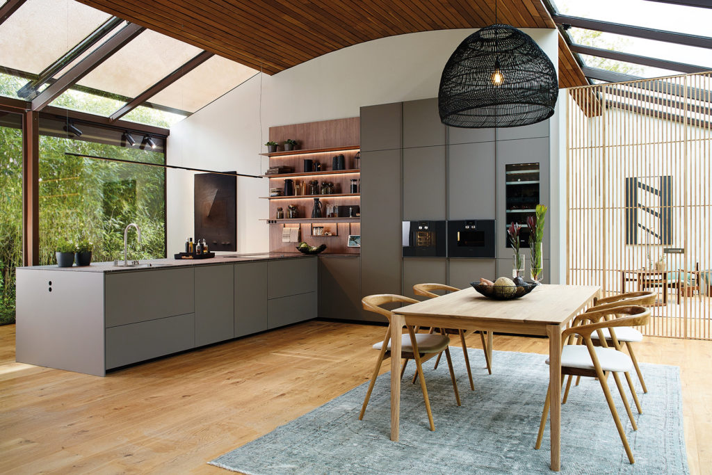 Open-plan grey kitchen with peninsula and shelving unit
