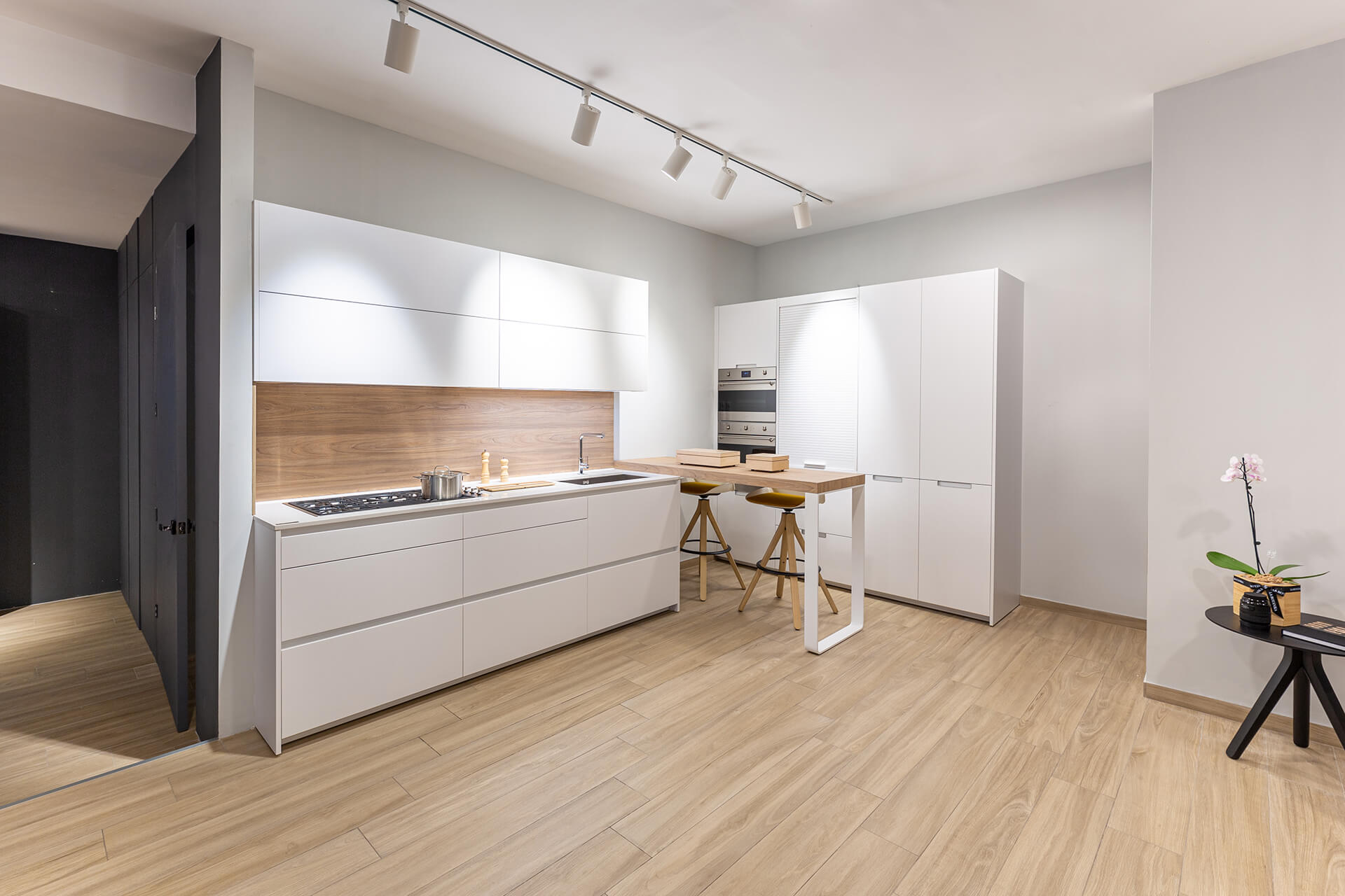 L-shaped white kitchen with worktop-mounted bar Santos Kitchens in Lima