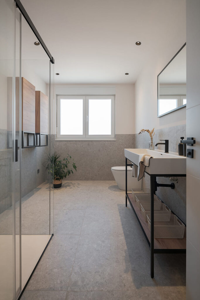 Bathroom with shower and grey floors.