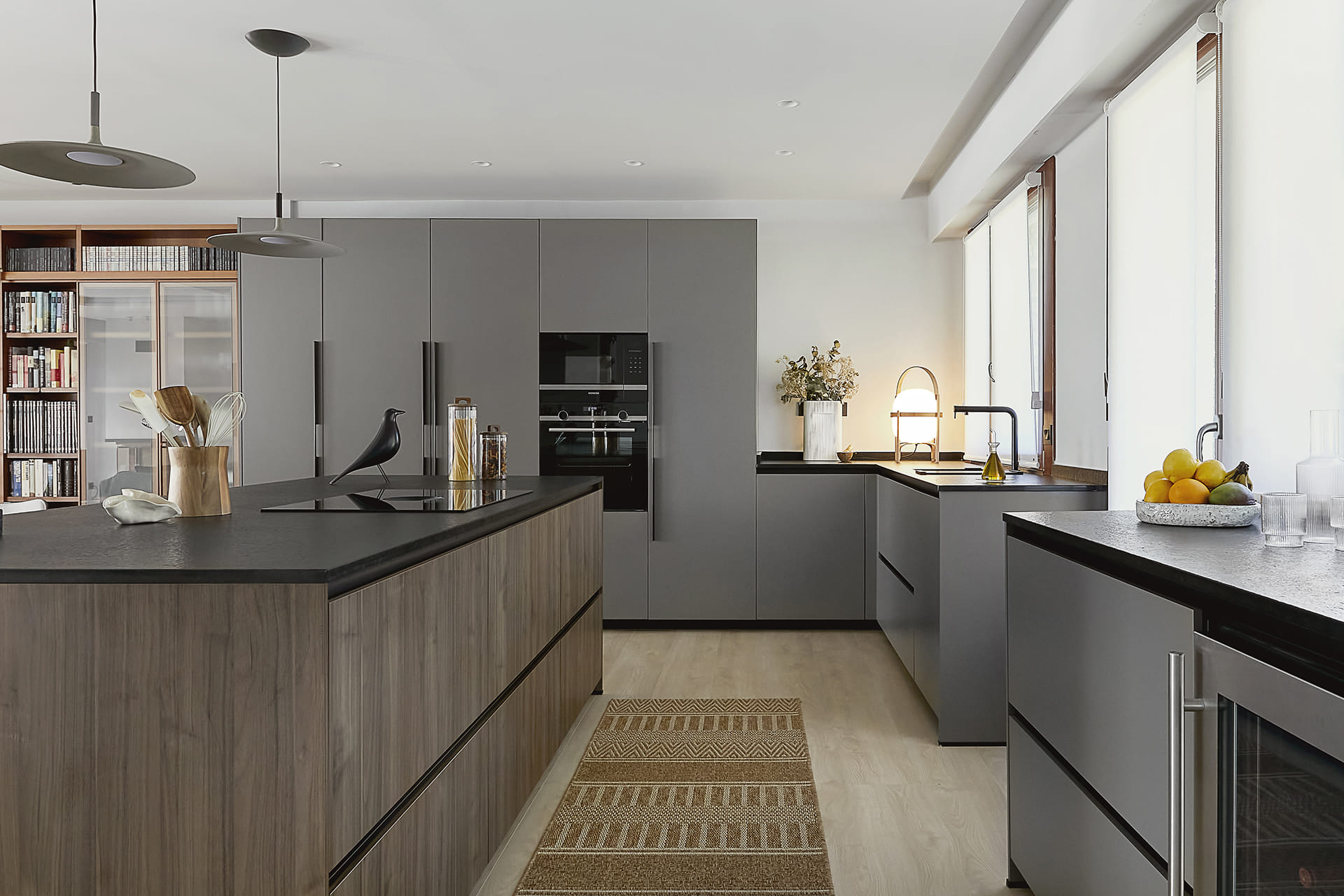 Grey and wood Santos kitchen open to the lounge with island clad in walnut.