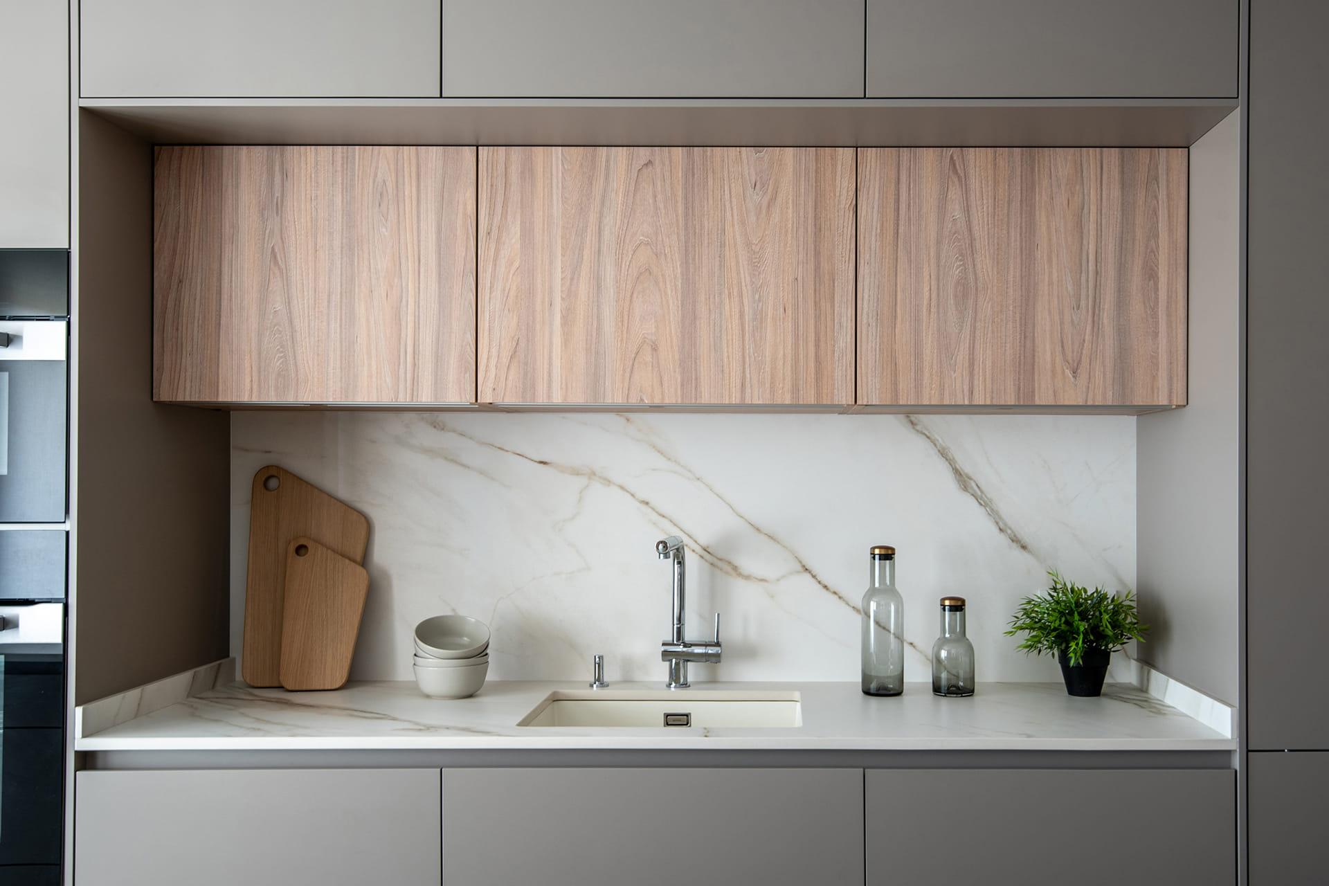 Close-up of the washing-up area on the sand grey kitchen island with light elm details.