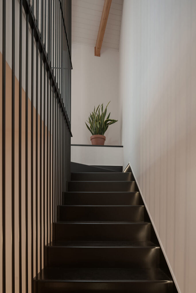 Black stairs, white walls, in a designer home.