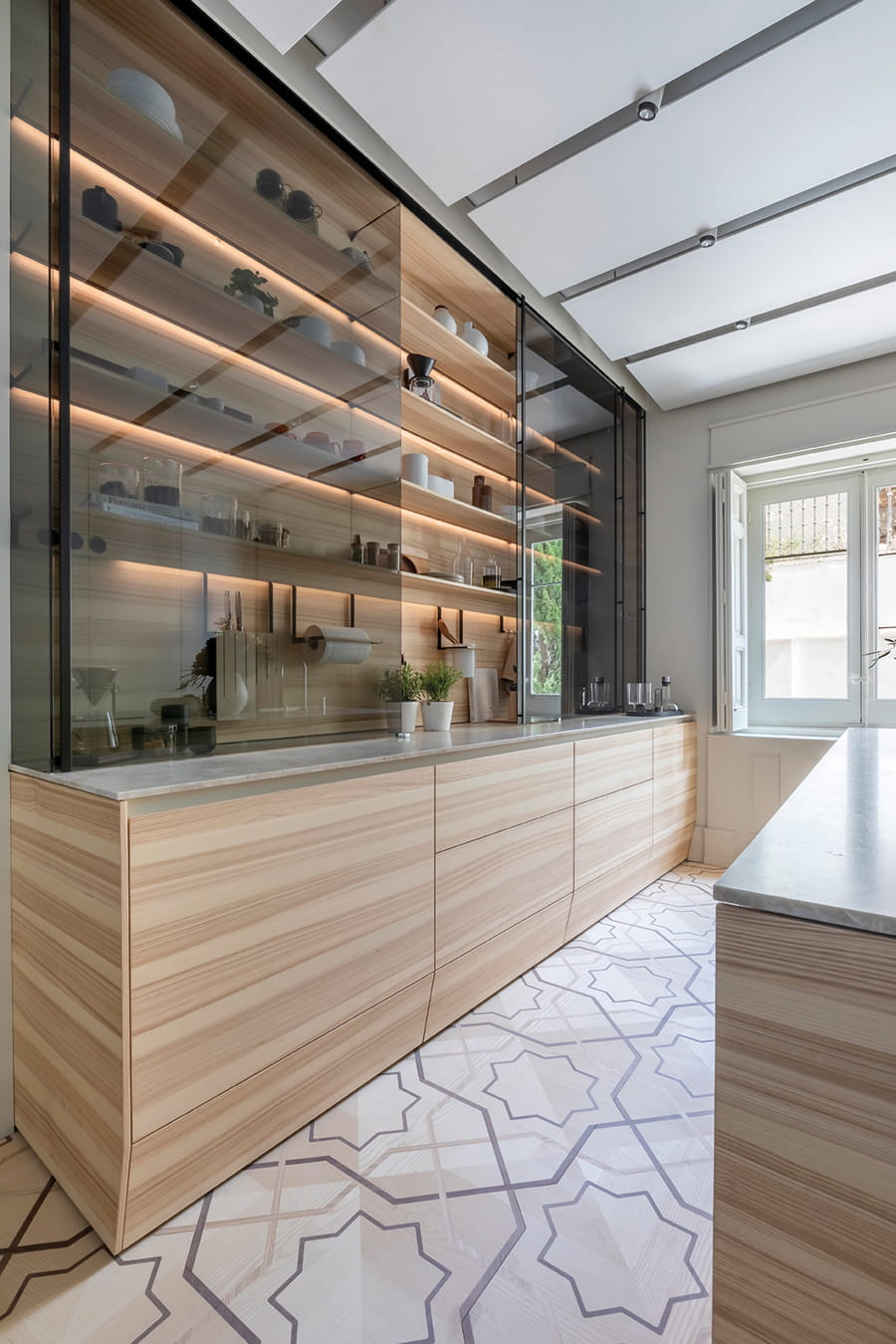 Cuisine Santos en bois de Frêne Olivier avec grande vitrine éclairée à Casa Decor 2024.