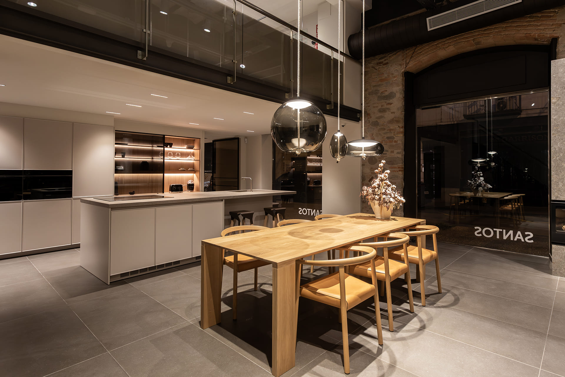 Kitchen with island and eat-in area at the Santos kitchen showroom in Girona.