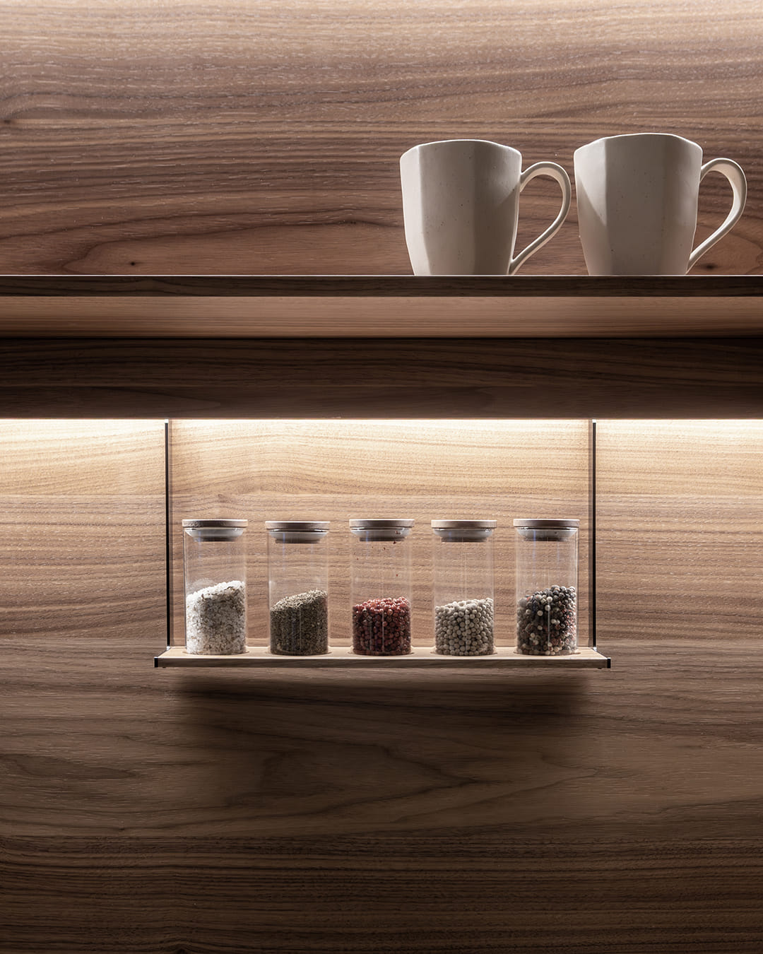 Close-up of spice tray and shelf in a grey and wood kitchen at the Santos kitchen showroom in Girona.