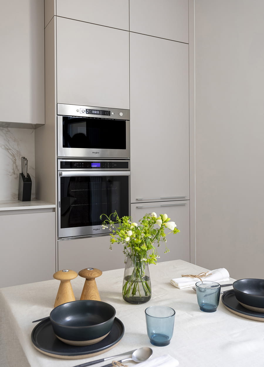 Breakfast area and tall units with built-in appliances in a Cashmere Santos kitchen.