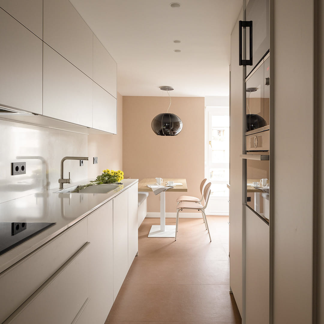 Cocina blanca estrecha con office de Santos en un proyecto de Módulo Arquitectura Interior.