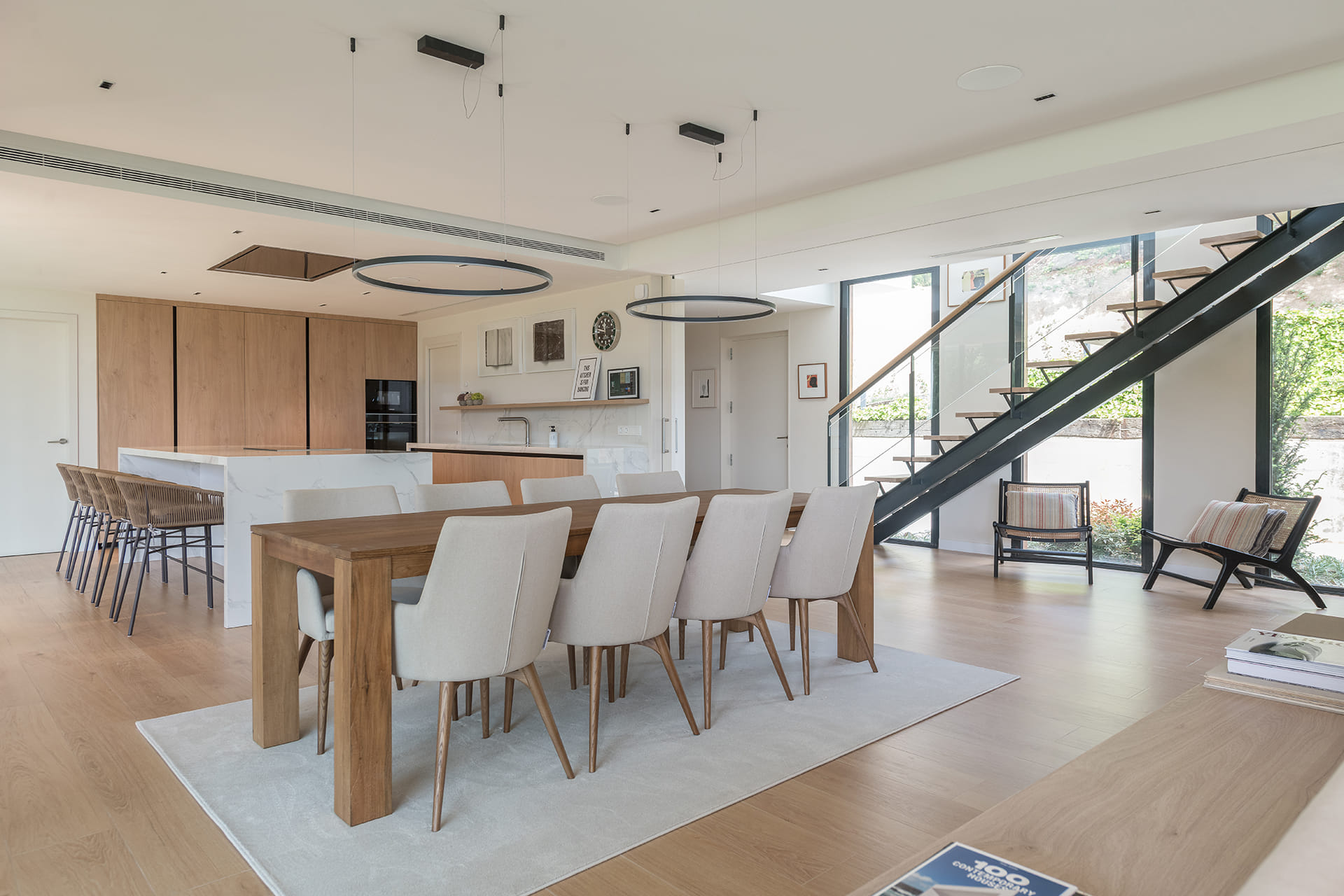 White and wood kitchen open to the dining area designed by Santos.