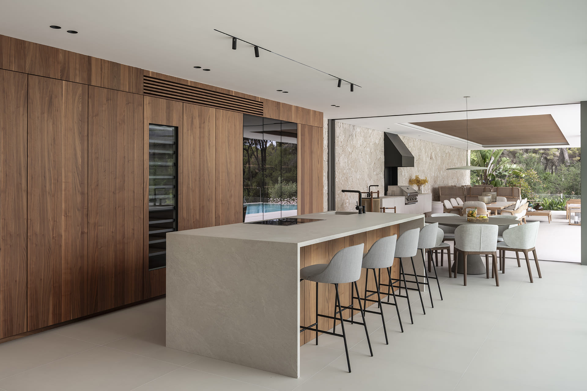 White and wood kitchen with island and stools open to the diner and the outside.
