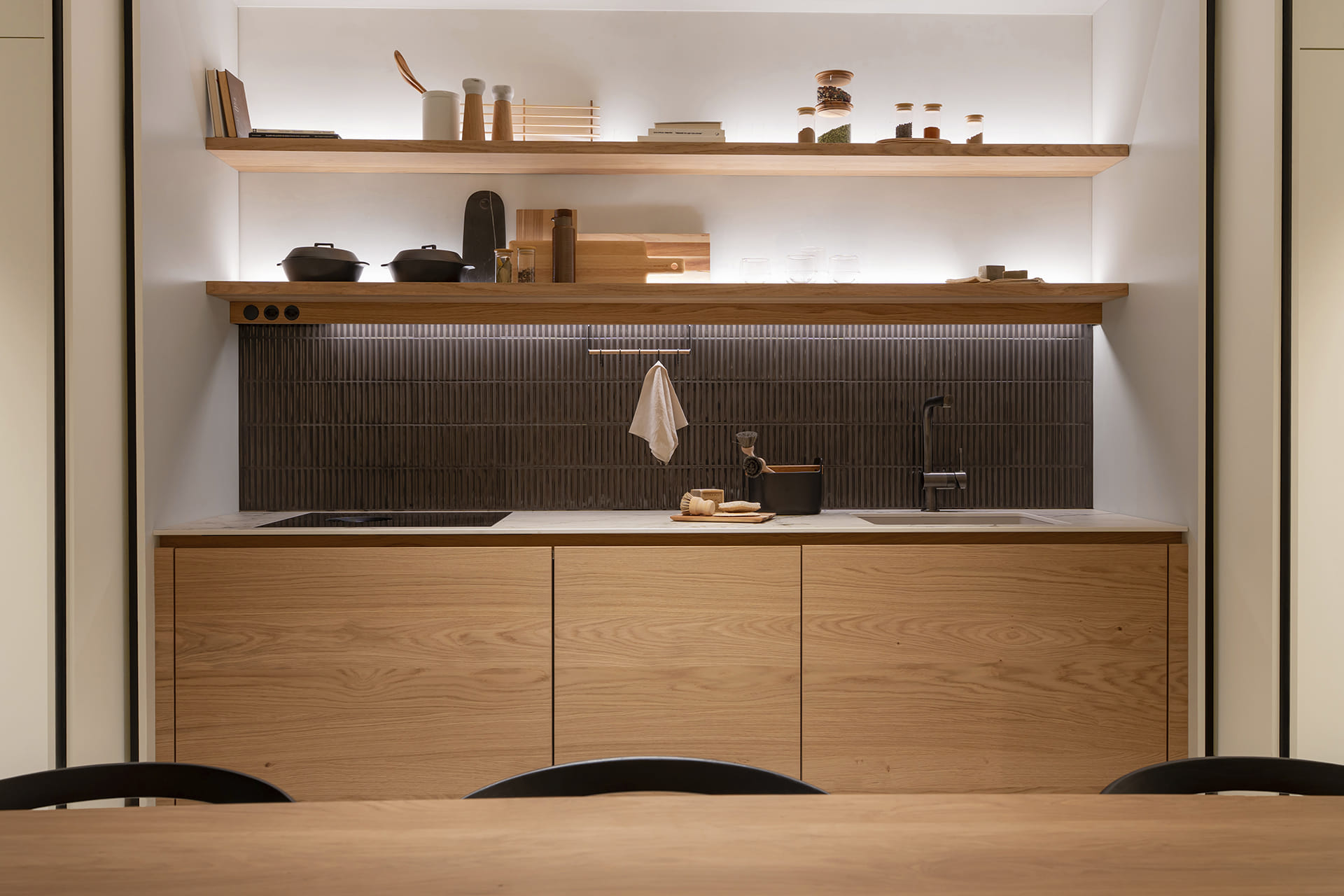 Single-wall kitchen with a double pocket door system at the new eba Genève showroom.
