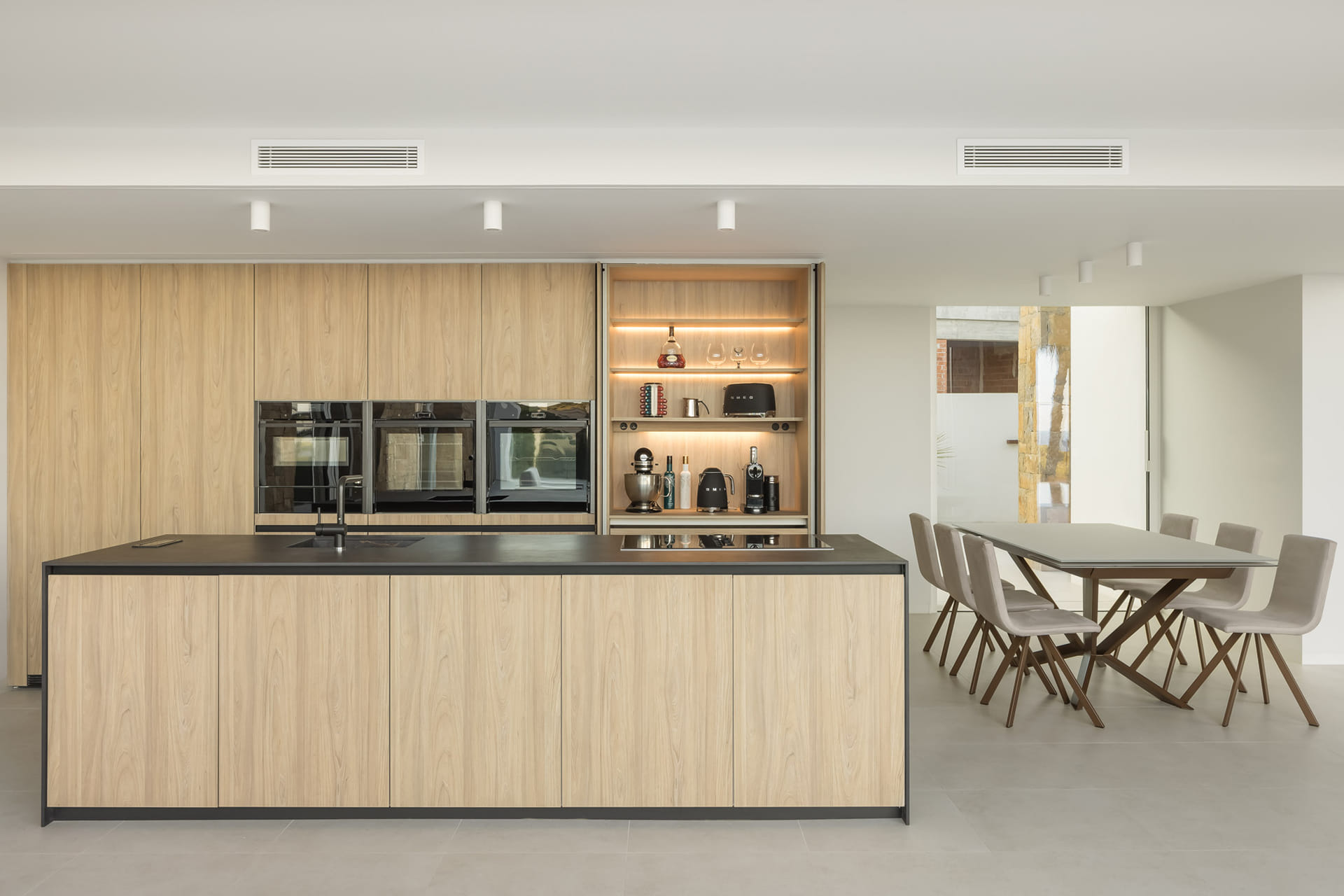 Black and wood kitchen open to the diner in a Santos Kitchens project.