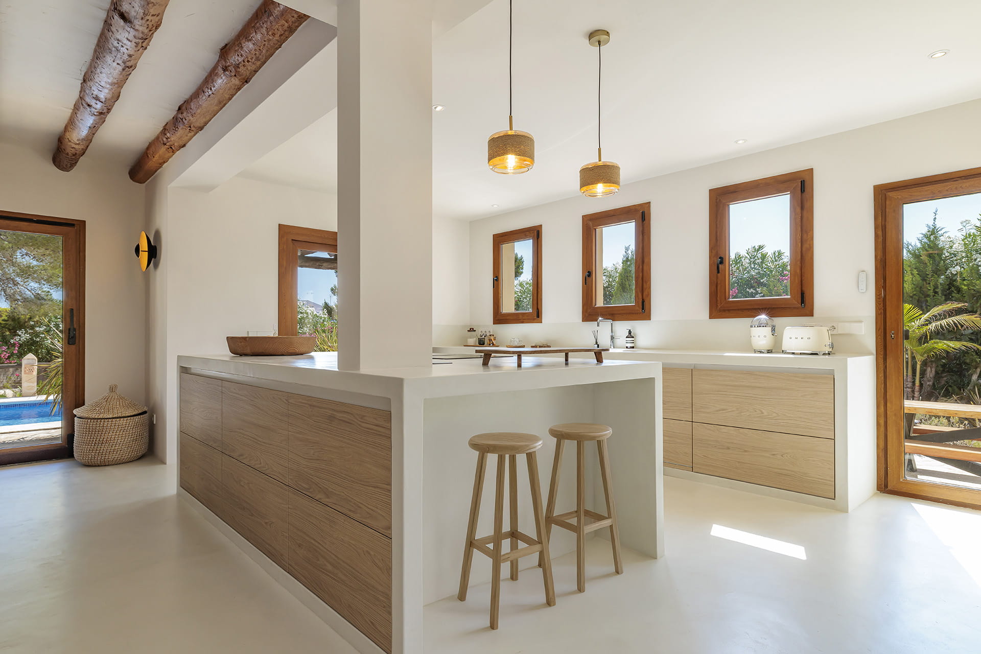 Santos kitchen with island and stools open to the outdoor area.