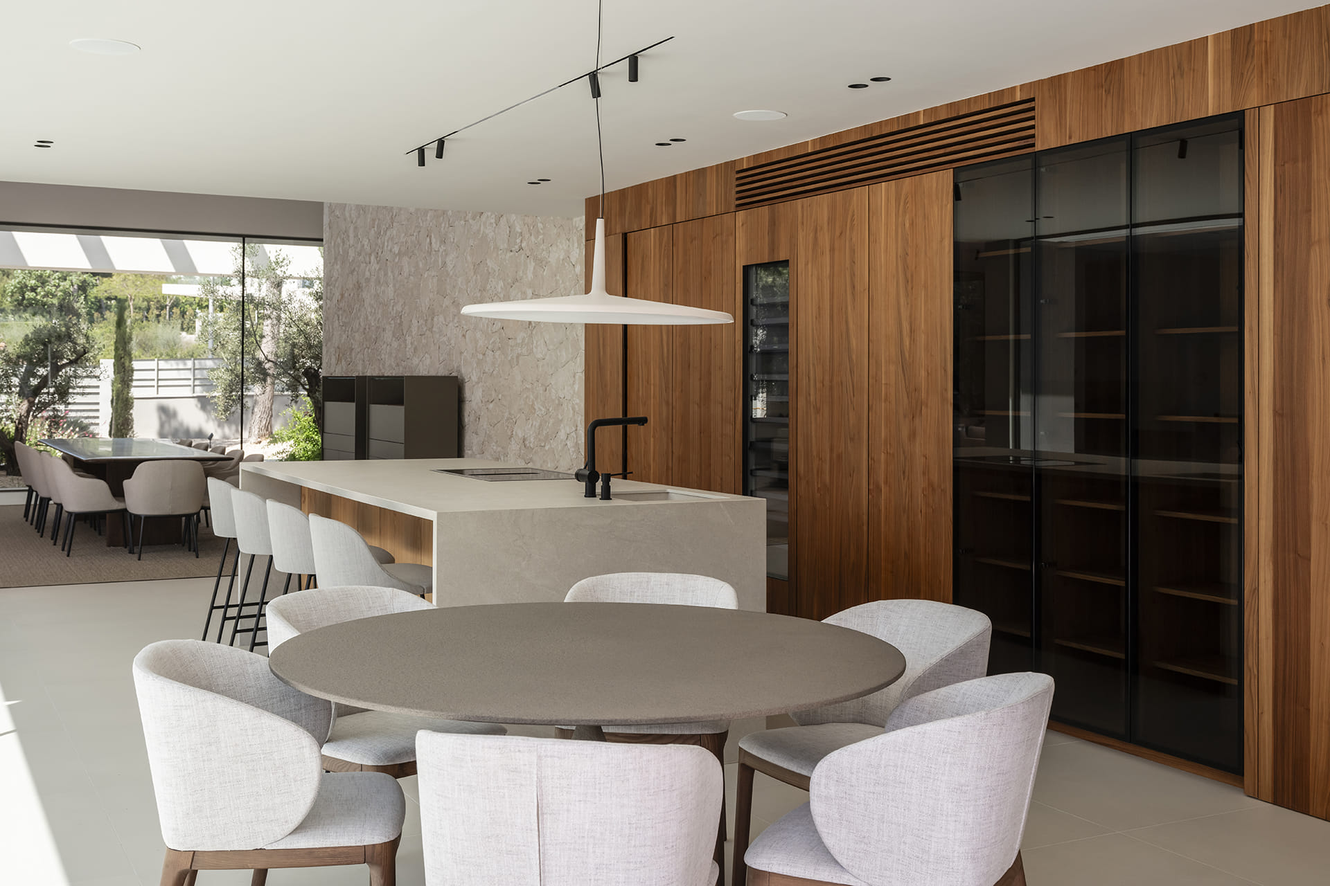 Dining area with a Santos kitchen with centre island in the background.