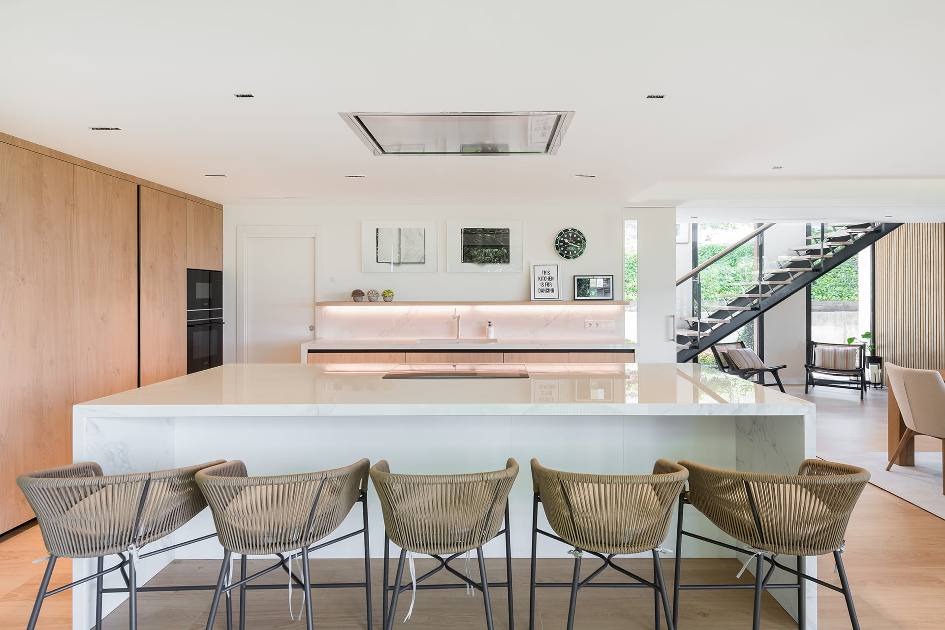 Kitchen island and stools in a Santos kitchen open to the outside.