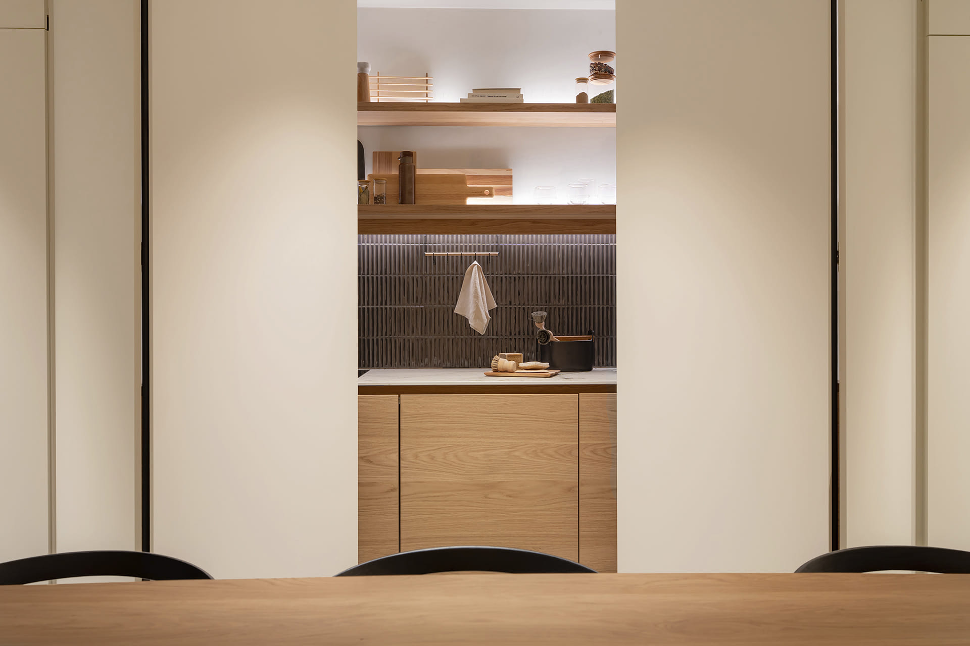 Double pocket doors that conceal a single-wall kitchen at the Santos Kitchens showroom in Switzerland.