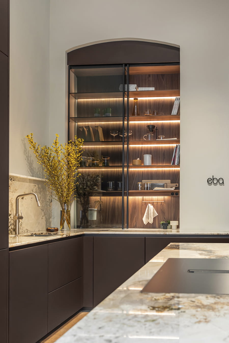 Close-up of glass door unit with interior lighting at the Santos Kitchens showroom in Switzerland.