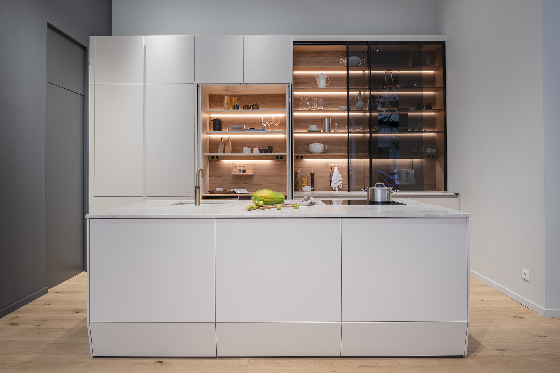 Cocina beige con isla y armarios escamoteables en la tienda de cocinas Santos en Zaragoza.