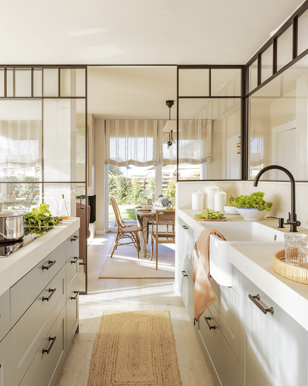Cocina clásica y atemporal de Santos abierta al salón con cerramiento de cristal.