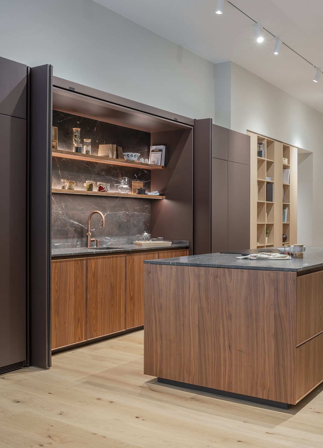 Cocina en madera con isla y puertas escamoteables en la nueva tienda de Santos en Zaragoza.