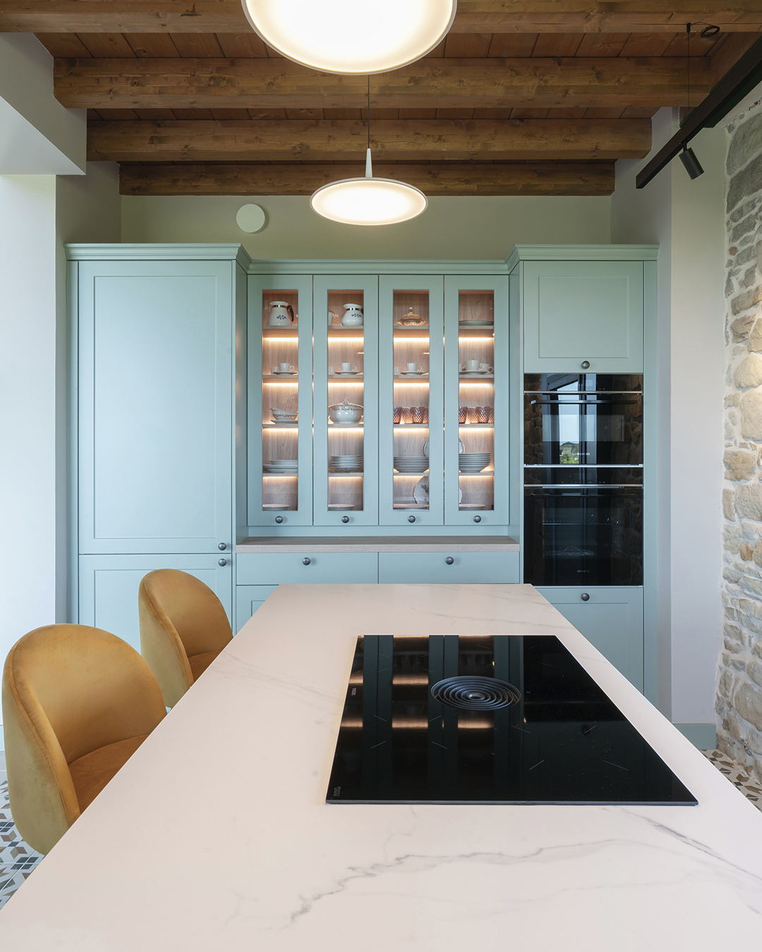 Isla con vitrocerámica con extracción integrada en una cocina clásica de Santos.