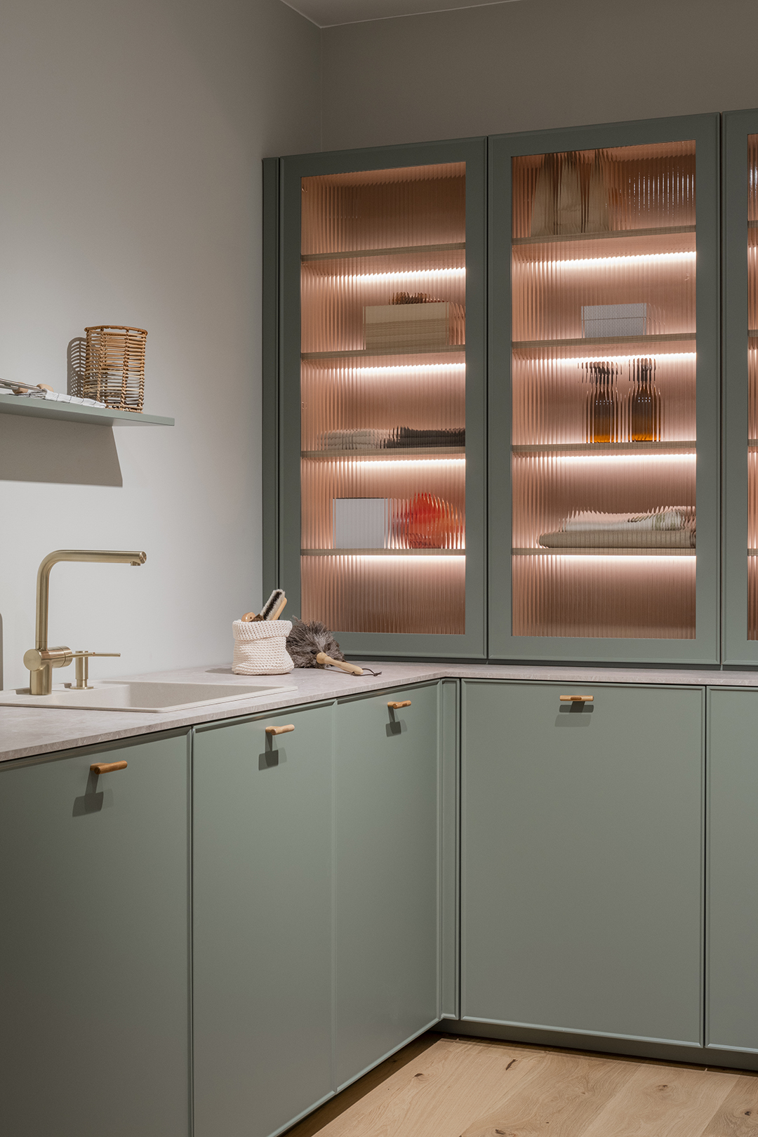 Lavandería con muebles verdes y vitrina de vidrio acanalado de Santos.