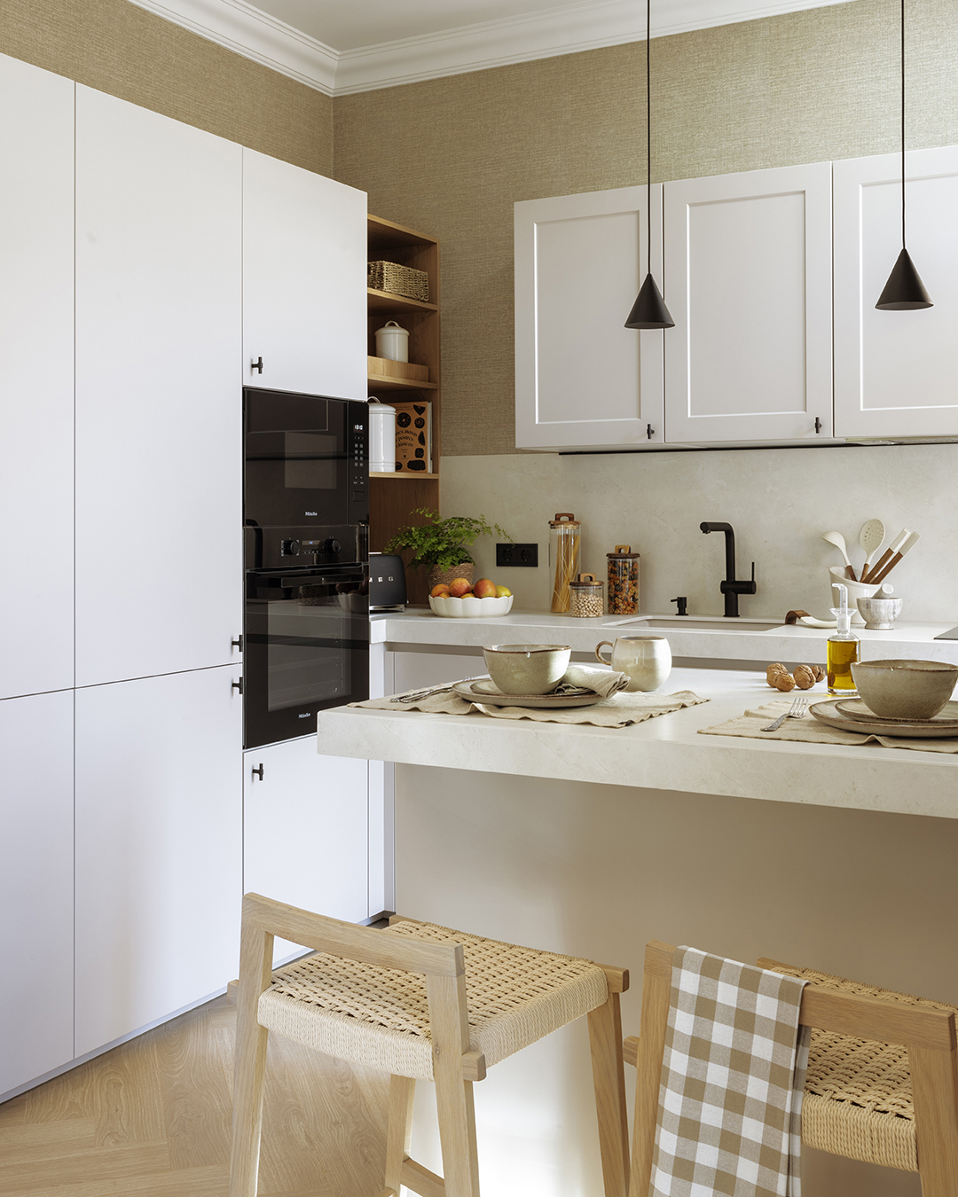 Península y armarios con electrodomésticos integrados en una cocina clásica diseñada por Santos.