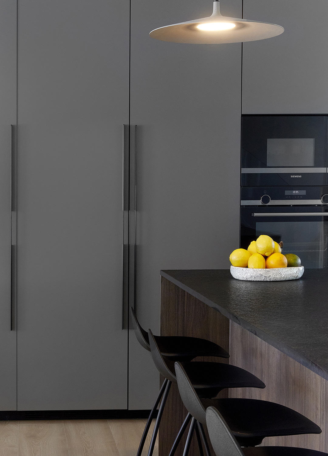 Armarios en columna e isla en una cocina gris diseñada por Santos.