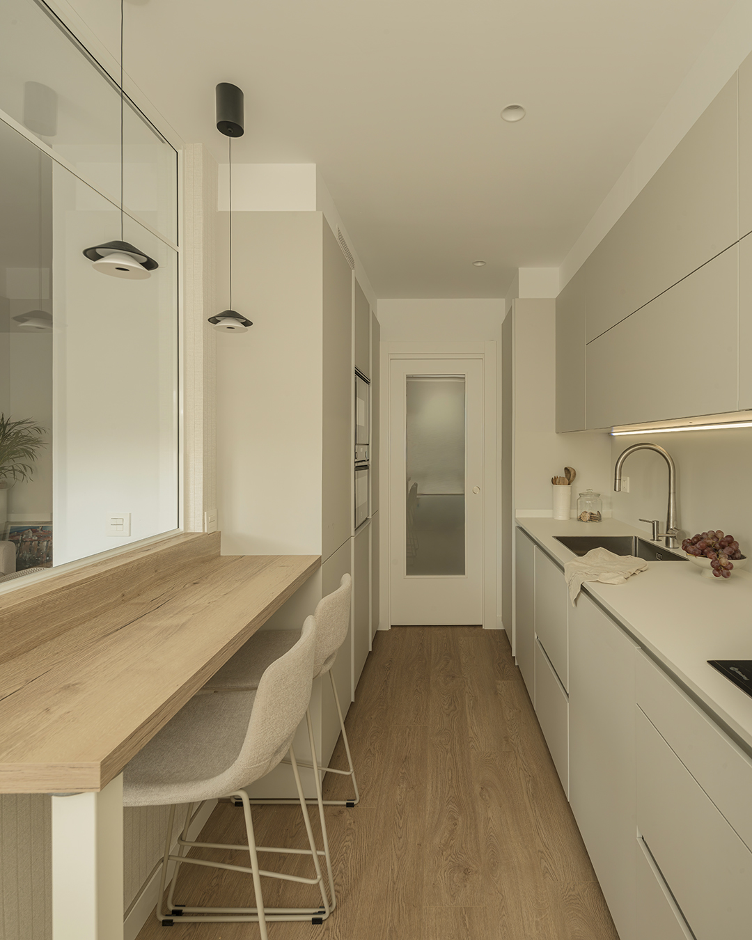 Cocina alargada y estrecha con barra de madera y cerramiento de cristal de Santos.
