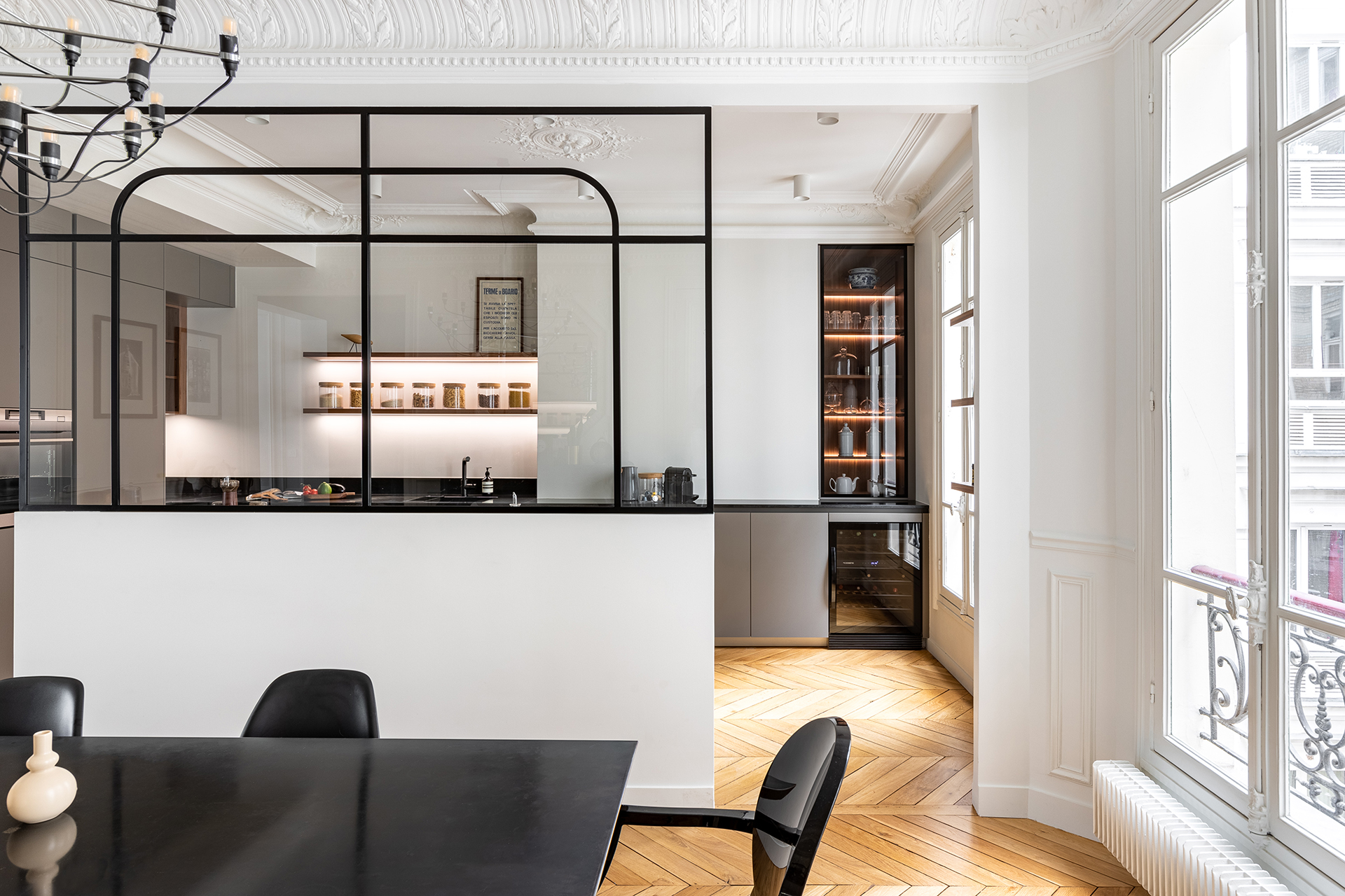 Cocina gris abierta al comedor con cerramiento acristalado de Santos.