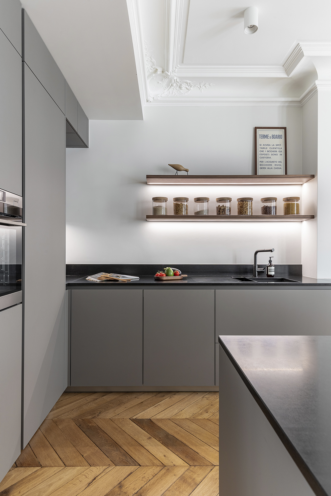 Cocina gris con estantes de madera en un proyecto de Cocinas Santos.