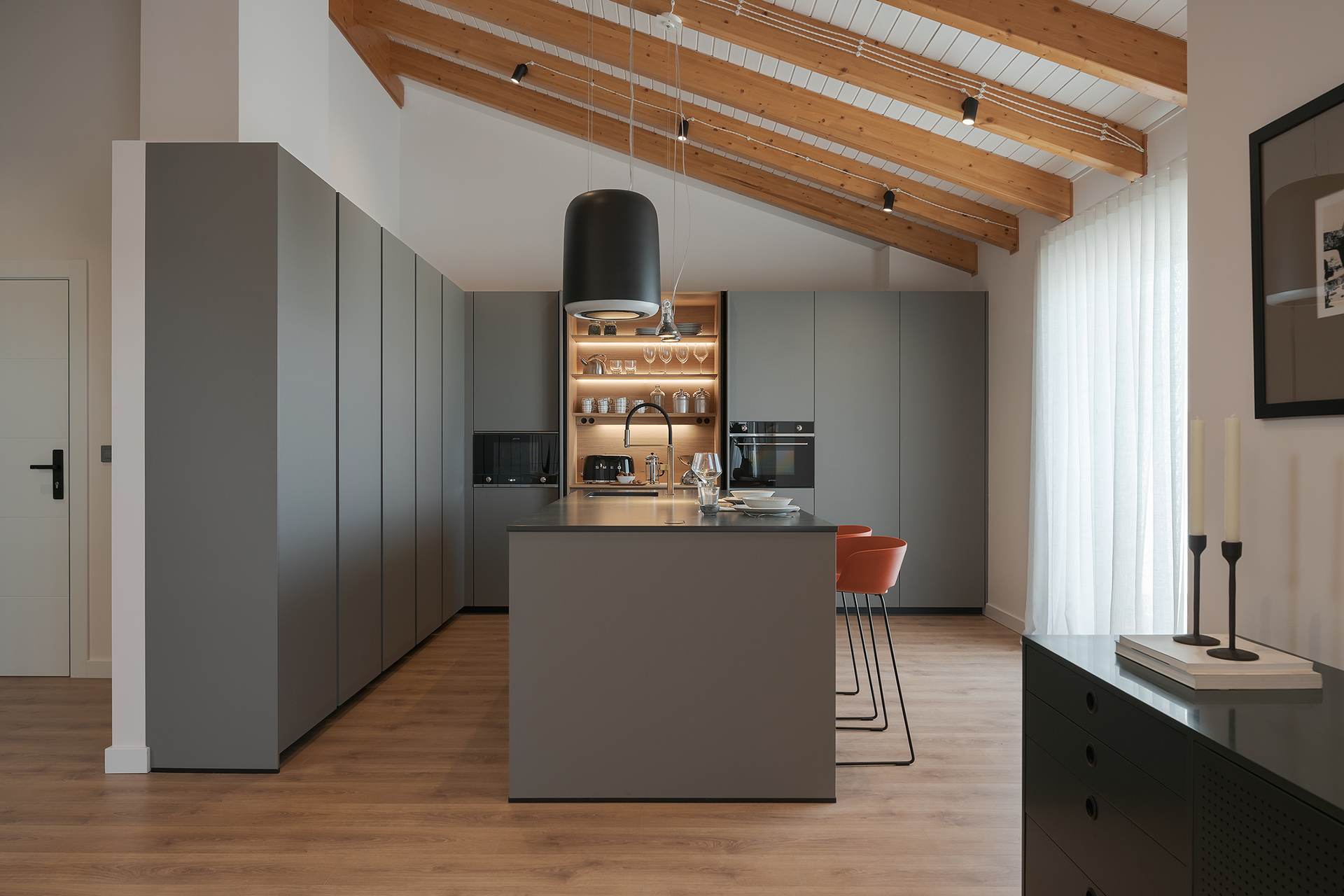 Cocina gris con isla y armario con puertas escamoteables de Santos.