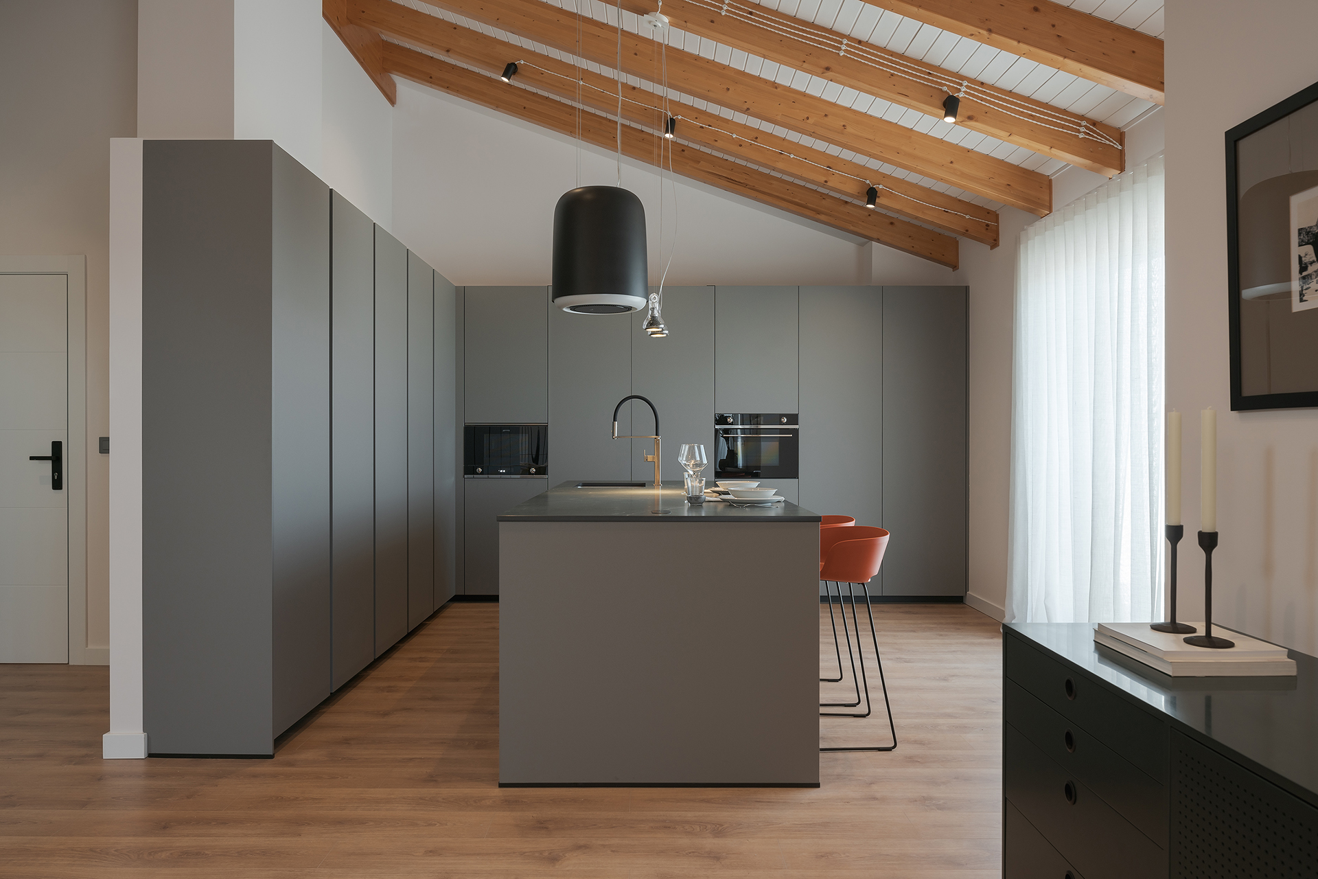 Cocina gris con isla y armarios en columna diseñada por Santos.