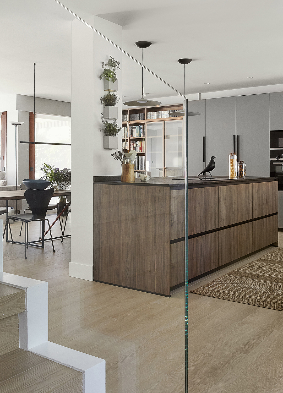 Cocina gris y madera con isla abierta al salón diseñada por Santos.