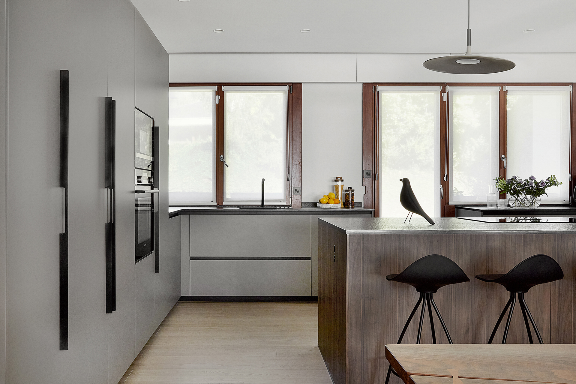 Cocina gris y madera con isla y armarios en columna de Santos.