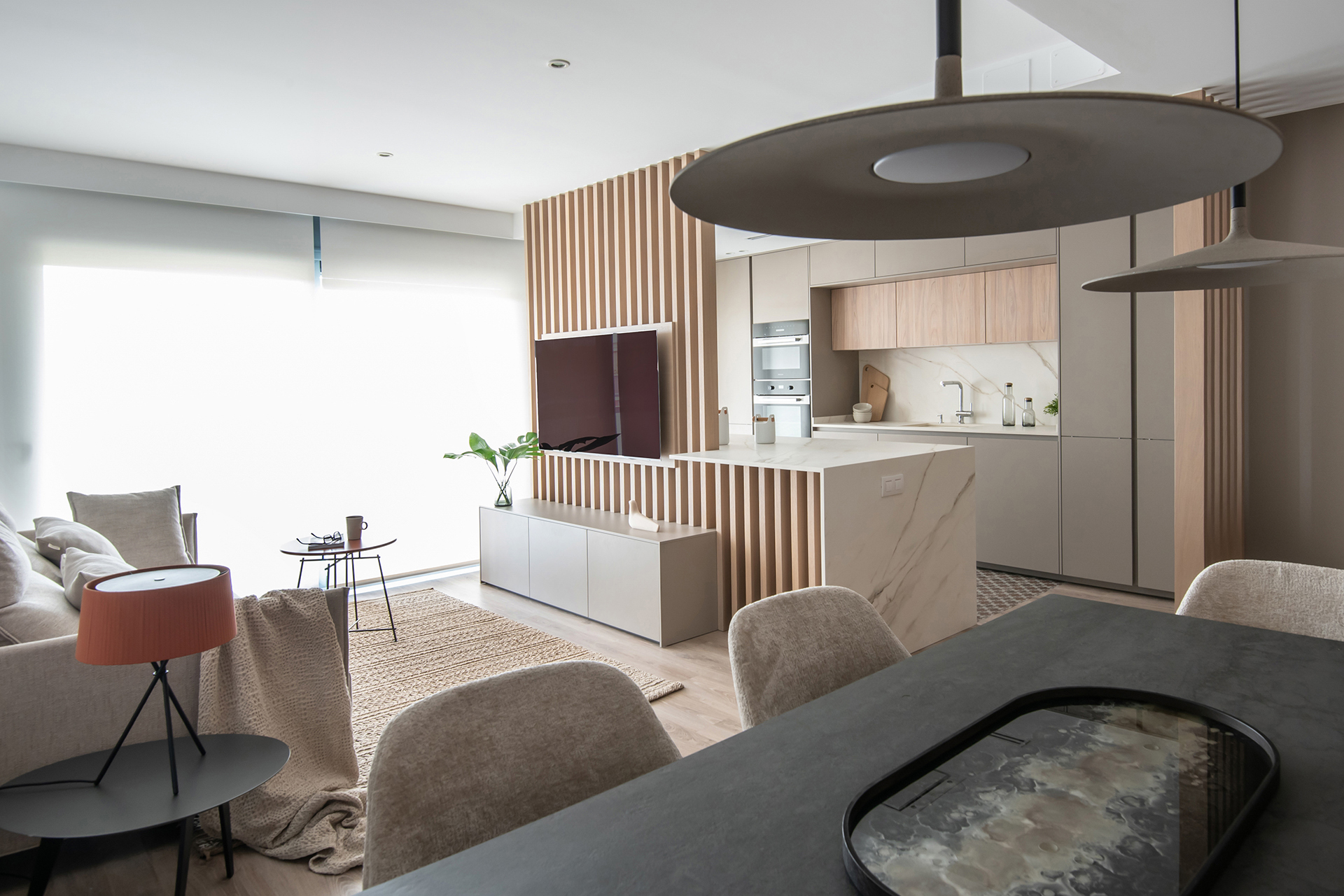 Cocina en gris y madera con isla abierta al salón comedor de Santos.