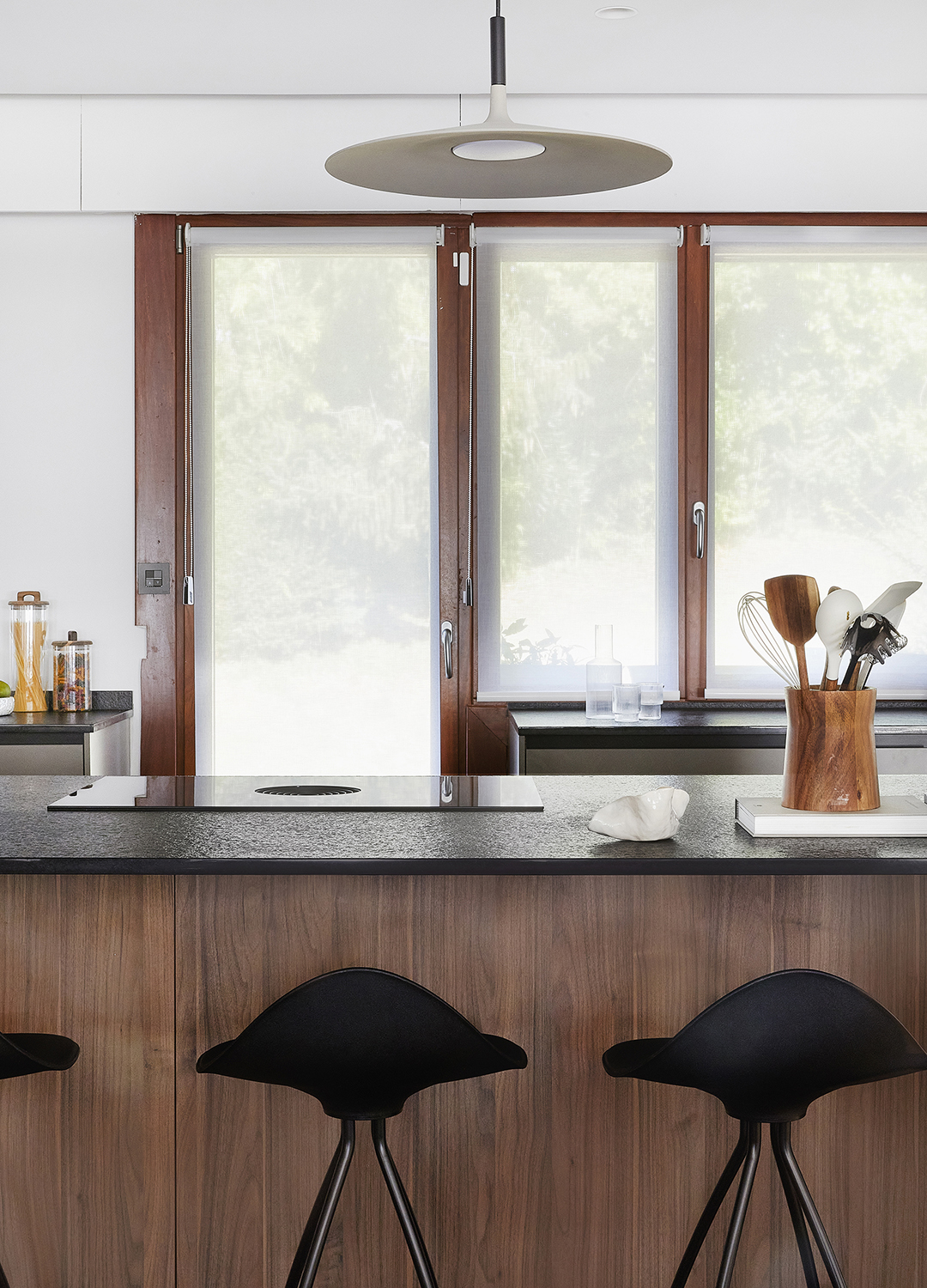 Cocina gris y madera con isla y taburetes diseñada por Santos.