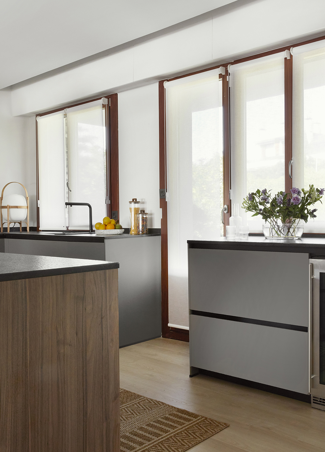 Cocina gris y madera con isla abierta a la zona de día de Santos.