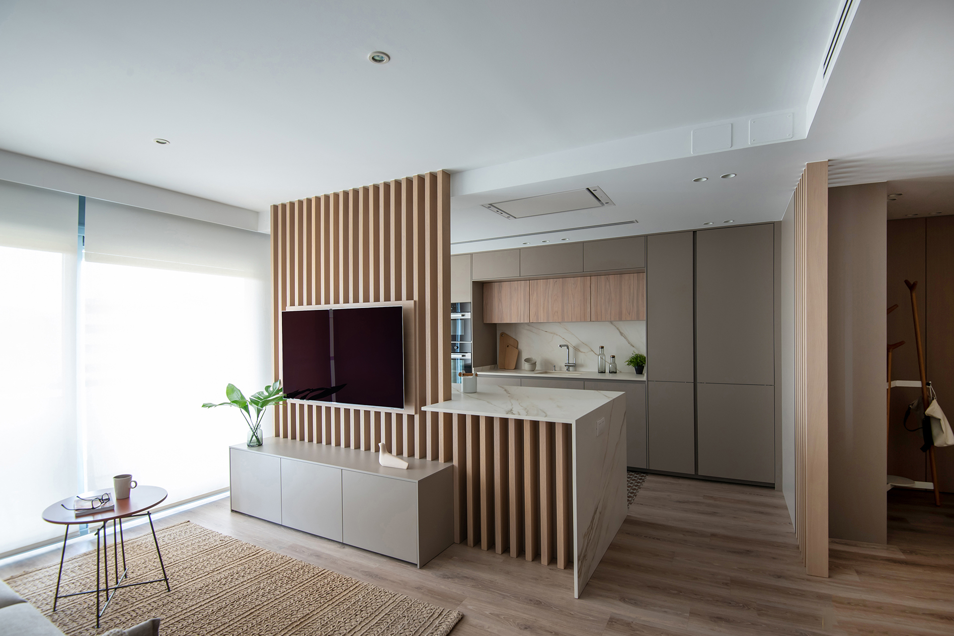Cocina gris y madera de Santos vista desde el salón de la vivienda.