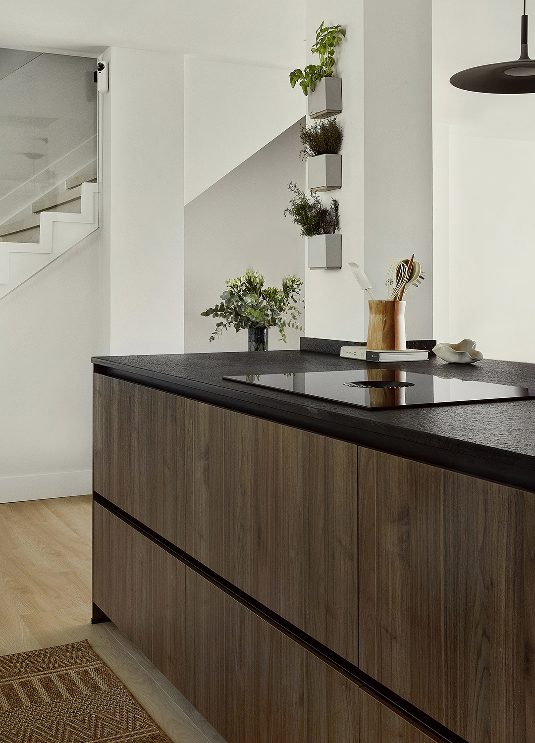 Isla de cocina en gris con acabados en madera diseñada por Santos.