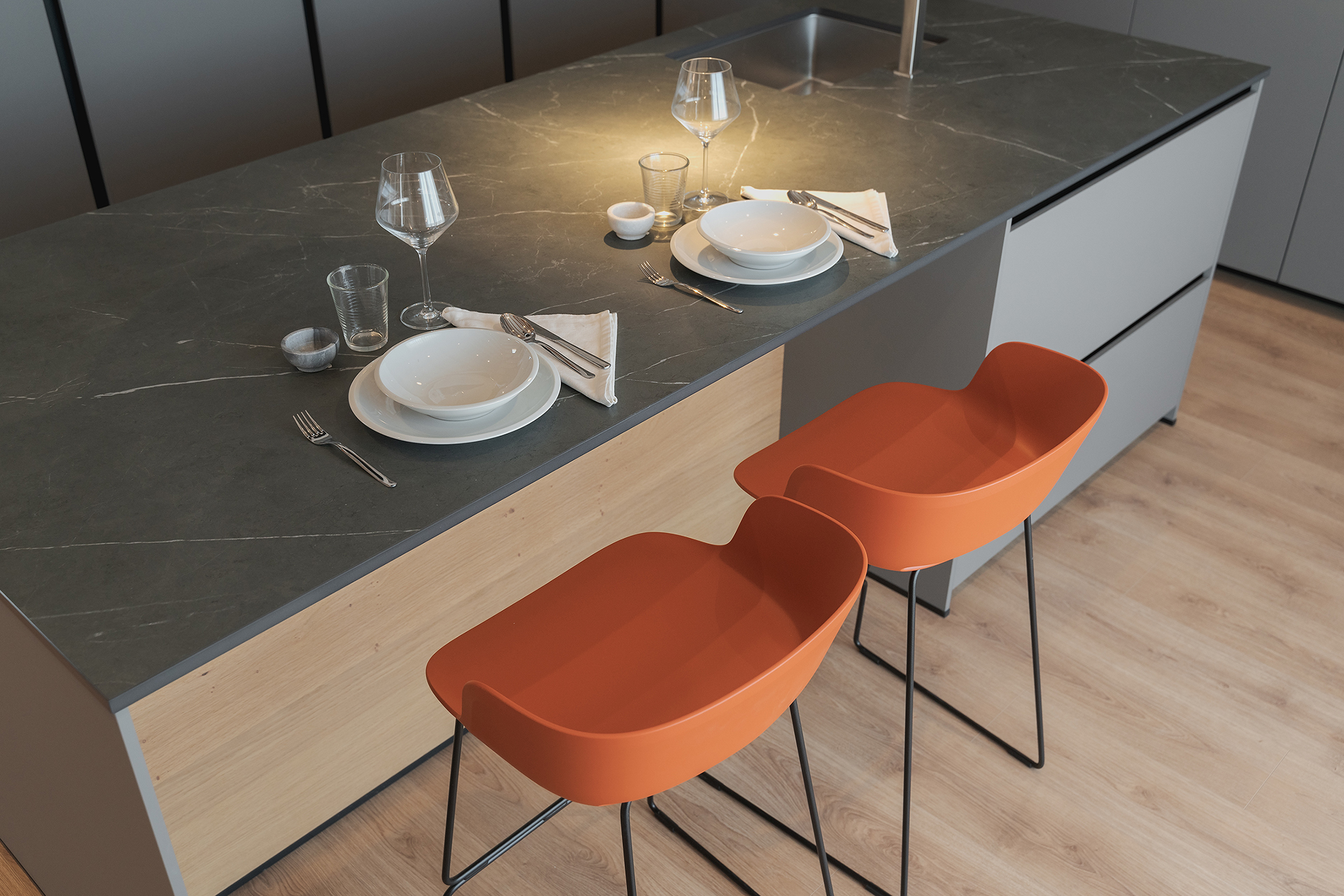 Isla de cocina en gris y madera con taburetes diseñada por Santos.