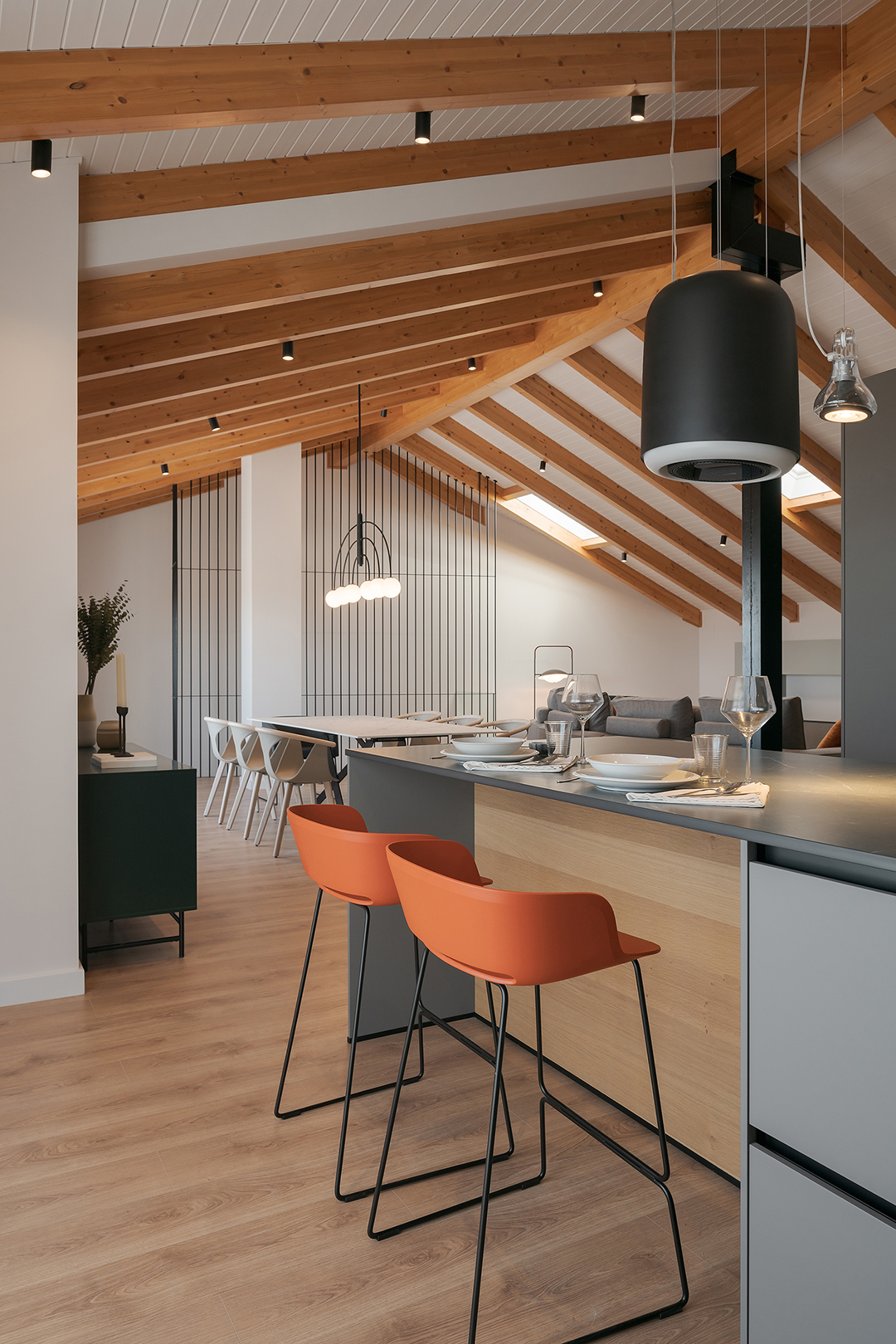Salón visto desde la isla de una cocina gris diseñada por Santos.
